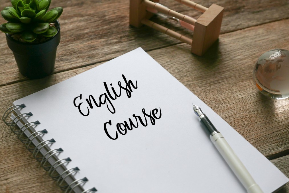 plant-sand-clock-glass-globe-pen-and-notebook-written-with-english-course-on-wooden-background_t20_znzNAx